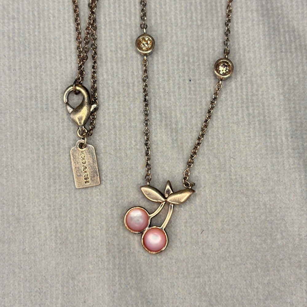 Coach Cherry Pendant Necklace with a rose gold-tone chain and pink cherry charm